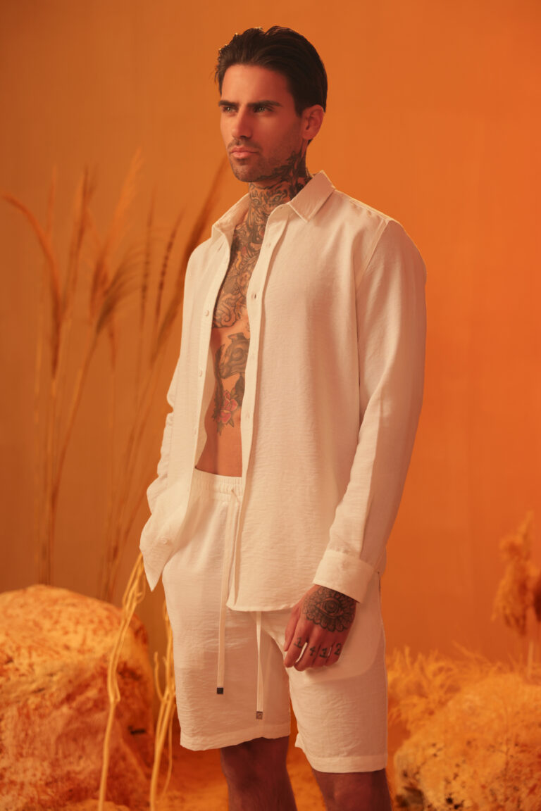 male model posing on an orange set with our new collection