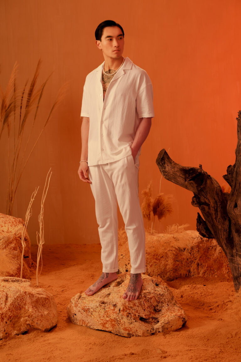male model posing on an orange set with our new collection
